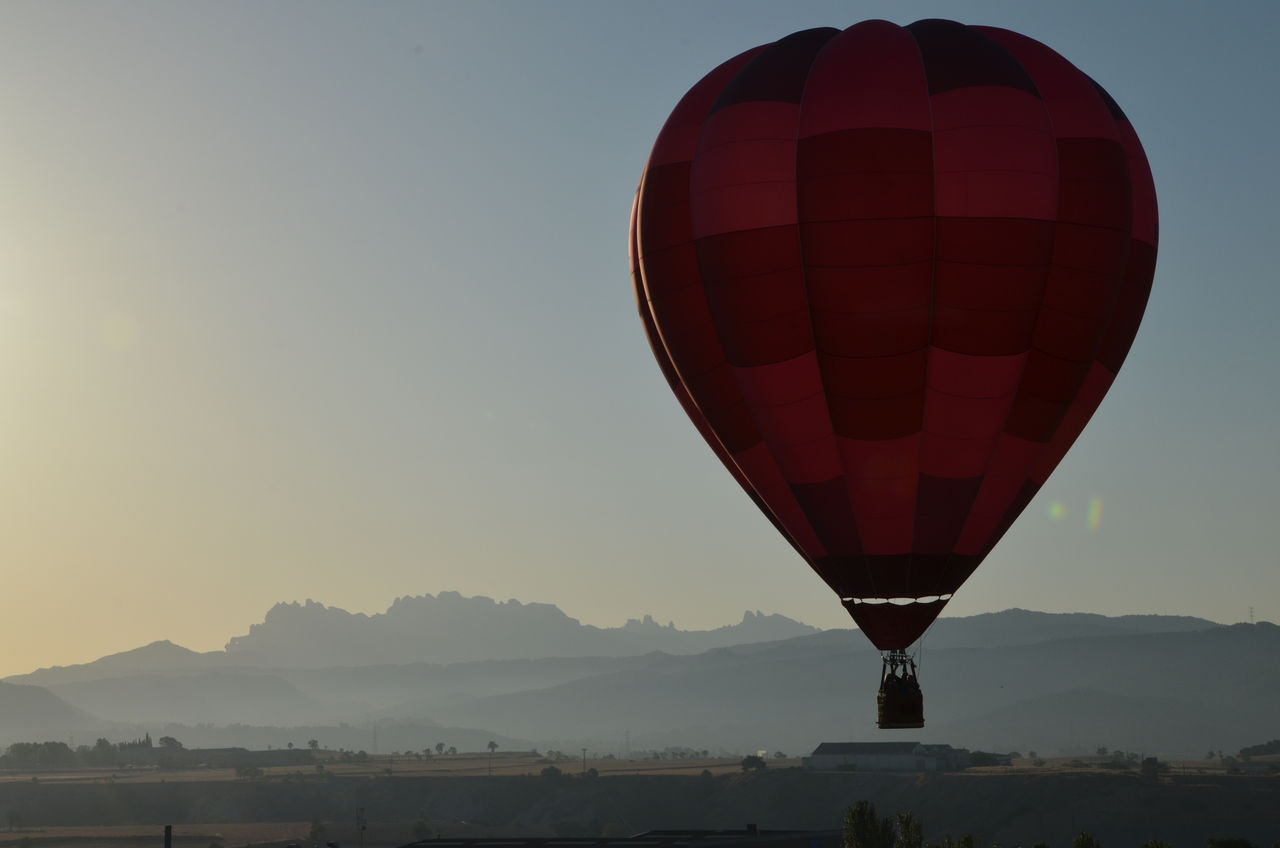 Balloon Festival Igualada, imatge d'un globus enlairat sobre un paisatge de muntanya a la sortida o posta de sol.