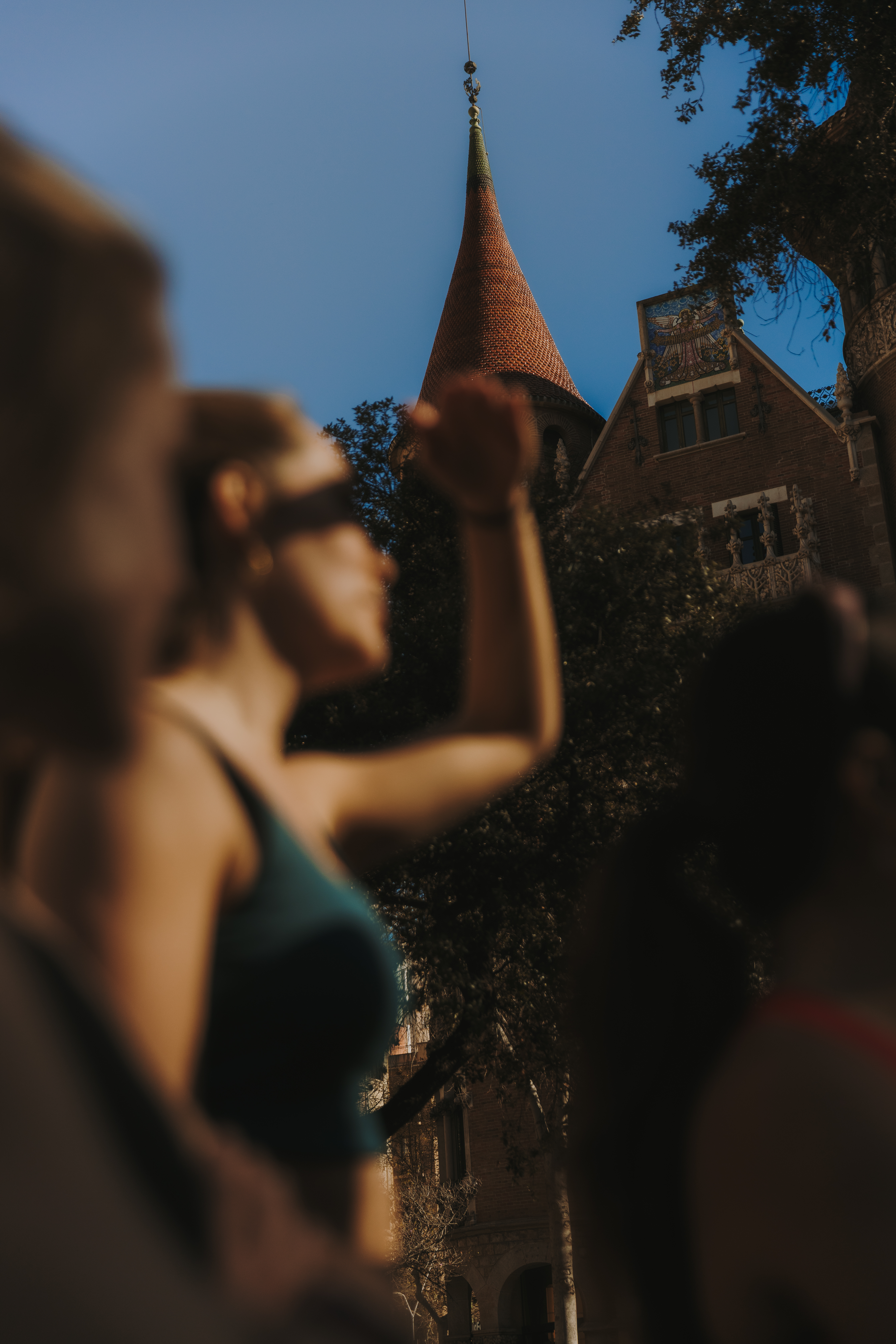 Personas corriendo bajo el sol, con la Casa de les Punxes al fondo.